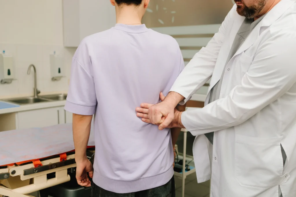 medical professional examining young man s back in 2026 04 04 23 38 06 utc