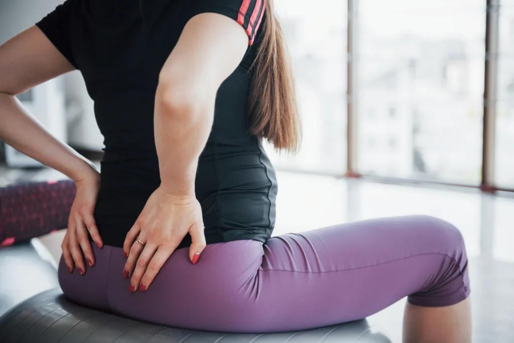 woman sitting on exercise ball with back pain 2026 03 24 07 14 02 utc