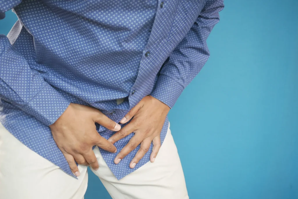 man in blue shirt holding lower abdomen 2026 03 16 02 14 30 utc