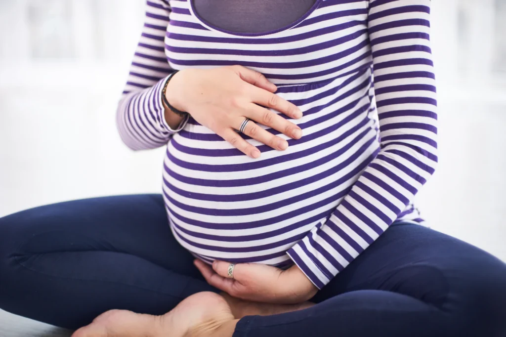 pregnant woman holding her baby belly indoors 2026 03 23 23 30 34 utc