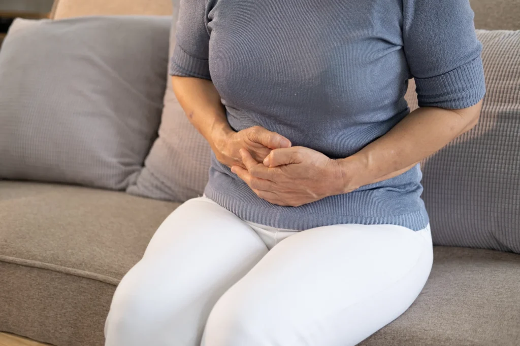 woman holding stomach while sitting on couch 2026 03 16 23 02 19 utc 1