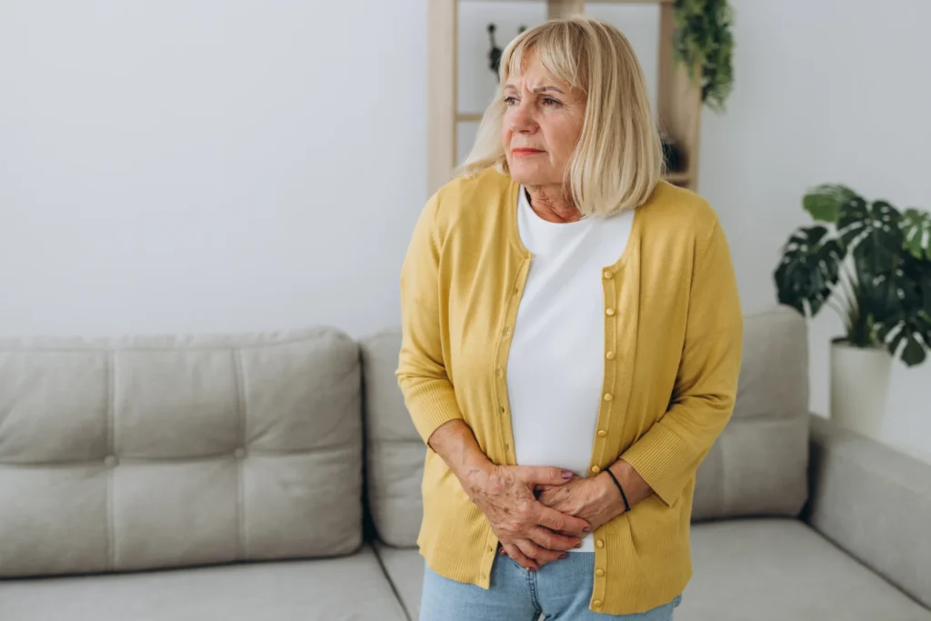 worried woman holding abdomen in indoor setting 2026 03 18 21 11 24 utc