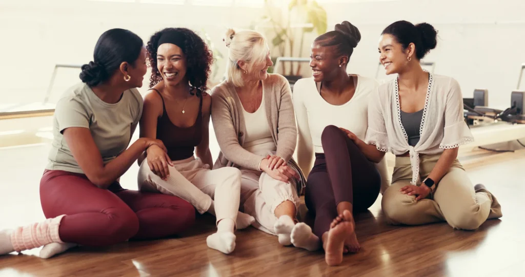 five smiling women sitting together in a bright fi 2026 09 25 03 53 14 utc